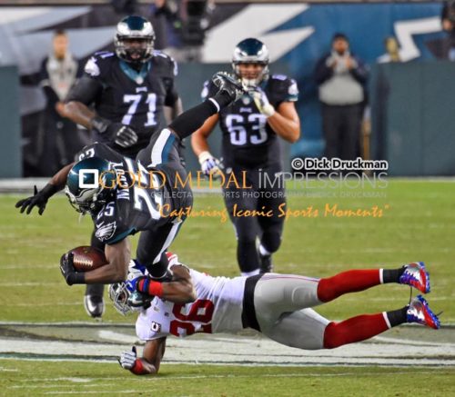 Philadelphia Eagles running back, LE SEAN MCCOY, leaps for a first down through the grasp of New York Giants safety ANTREL ROLLE, in the first quarter. The Eagles won 27-0.