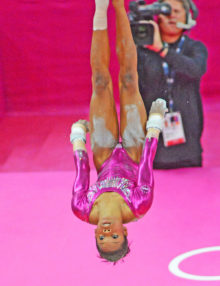USA gymnist Gabrielle Douglas eyes the world upside down as she competes on the uneven bars at the London Olympics. Gabby won the gold.