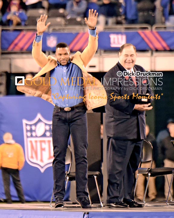 New York Giants Defensive End, MICHAEL STRAHAN, raises his arms to the crowd during the Half time ceremony recognizing his enshrinement into the NFL Pro Football Hall of Fame.