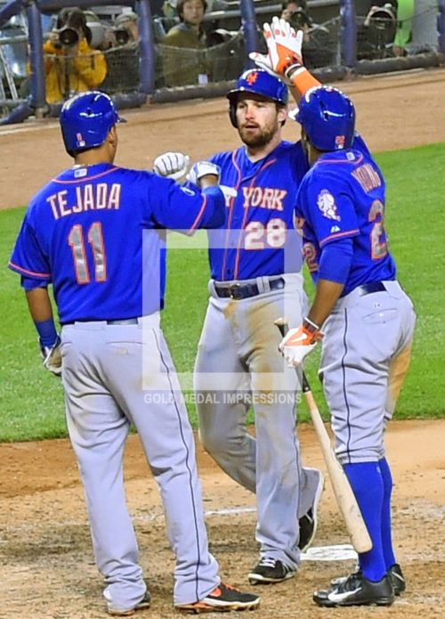 New York Mets second baseman, Daniel Murphy, celebrates hitting a 3run home run in the bottom of the 5th inning at Yankee Stadium with Ruben Tajada, and Eric Young, JR.The Mets went on to win game2 of the Subway series 12-7.(AP Photo/Dick Druckman)