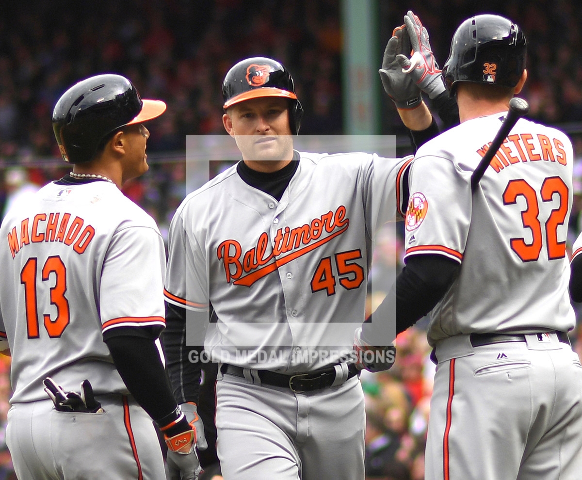 Baltimore Orlioles right fielder MARK TRUMBO is congratulated by MANNY MACHADO and MATT WIETERS after hitting a three-run home run in the third inning off of Boston Red Sox starter David Price. The Orioles went on to defeat the Boston Red Sox 9-7 to start the season 6-0 the best start in the major leages and the best start in Orioles franchise history.